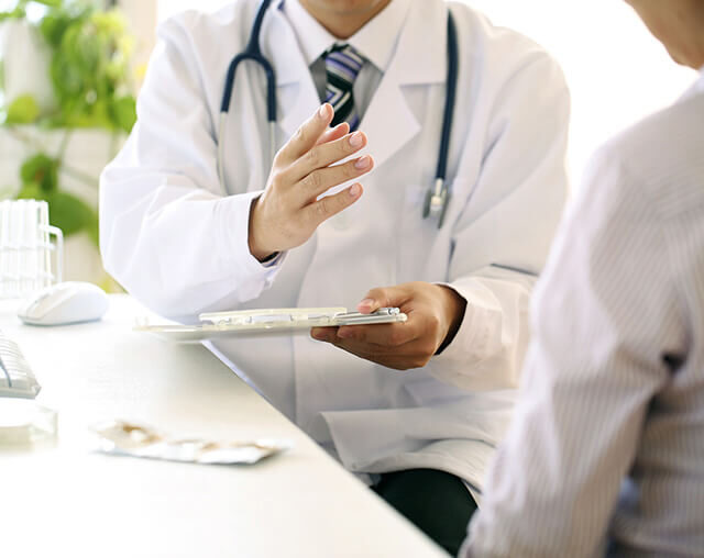 医師が患者の血圧測定結果を確認しながら丁寧に説明している診察風景。高血圧治療と生活習慣改善をサポートする循環器専門医の様子。