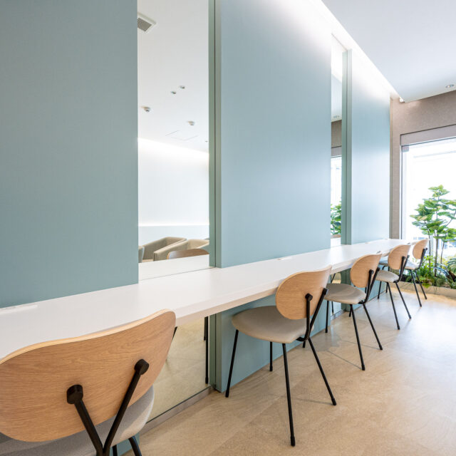 ティファニーブルーを基調とした、落ち着きと清潔感のある内科・循環器クリニックの院内風景。やさしい照明とナチュラルな木の質感が調和した空間。