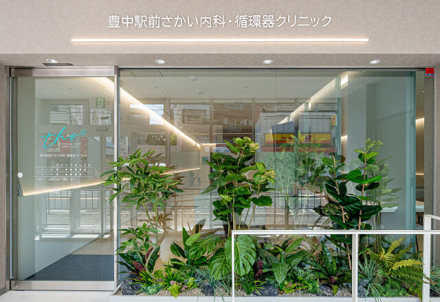豊中駅前さかい内科・循環器クリニックのエントランス。ミントブルーを基調とした清潔感ある外観と、駅近で通いやすい立地が特徴です。